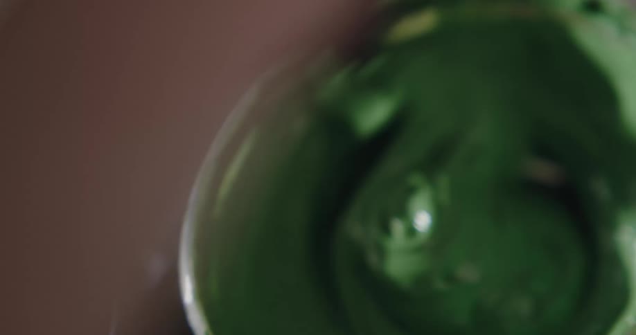 A person is mixing paint in a bowl