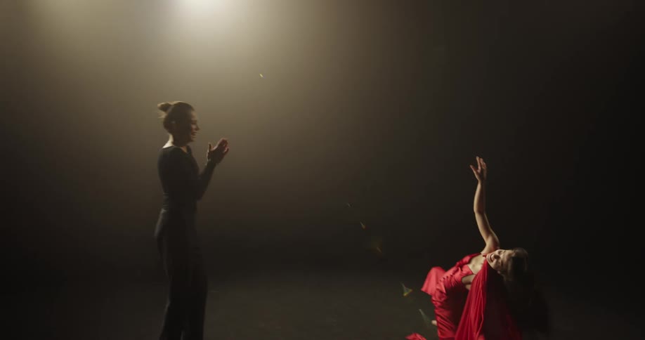 Two women in a room with one dancing and then they both hug