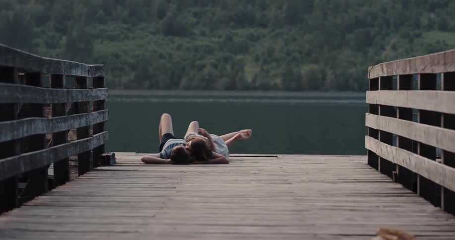 A couple lay down together on the pier