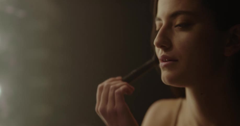 A woman is applying makeup on her face