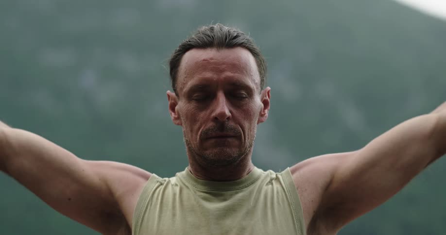 A man is standing outdoors and stretching