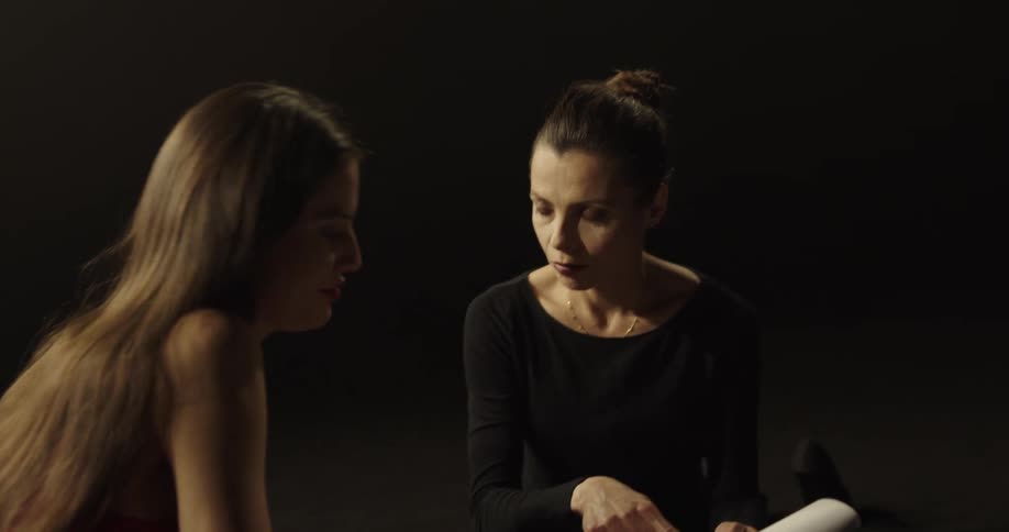 Two women sitting looking at a script