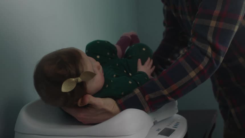 Man places an infant on a baby scale