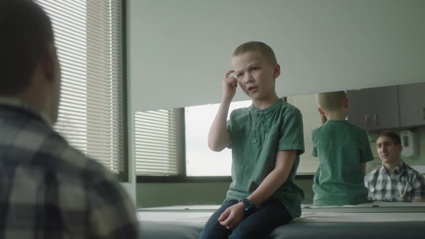 A young boy explains to a doctor why he isnt feeling well