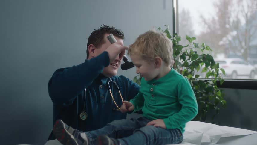 Male checking childs ear