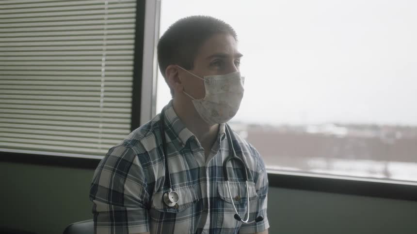 A man is talking while wearing a mask