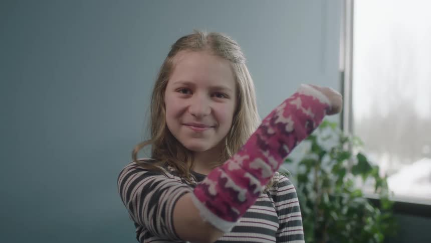 A girl is in a doctors office and has a cast on her arm