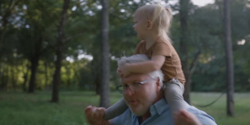 A grandfather and granddaughter dancing outside