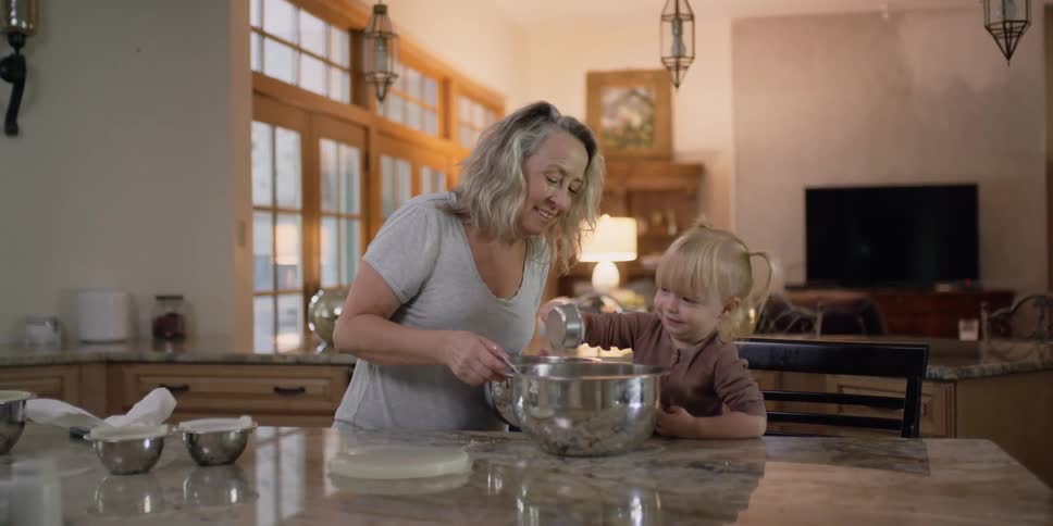 A woman is showing a child how to cook