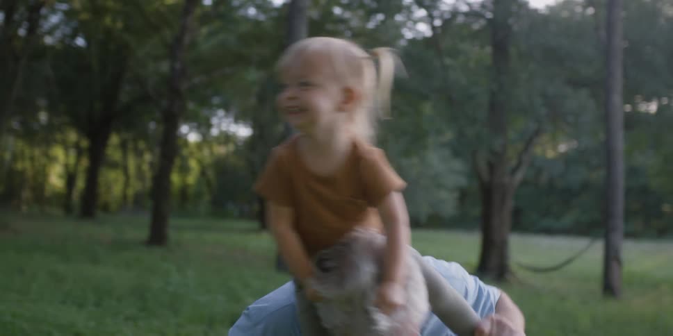 Grandfather gives granddaughter a piggyback rides wobbling back and forth as they smile