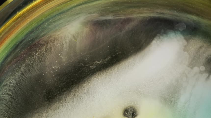 Colored sediment moves clockwise around a crater