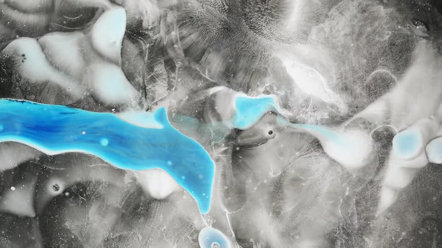 Blue and white liquid spread on a black surface