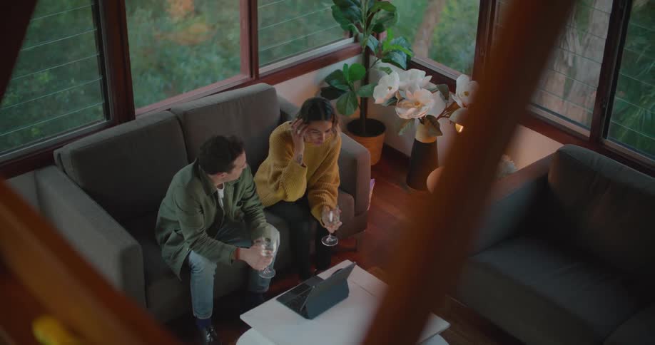 A man and woman sitting on a couch talking with each other