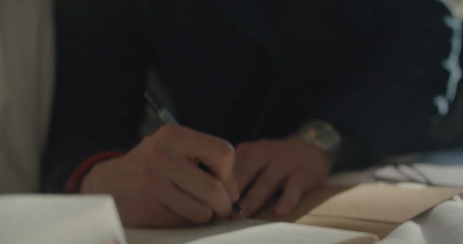 A man takes notes while sitting in bed