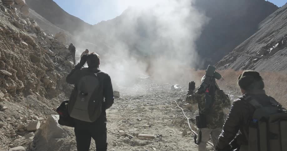 A group of people are walking across a mountain range