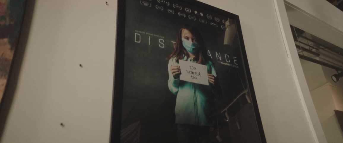 A room with a picture in picture frame with a wall and doorway in the background