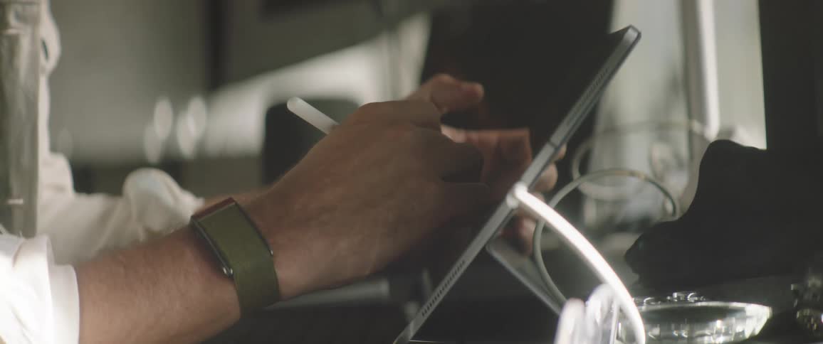 A man is drawing on an electronic tablet with a stylus pen