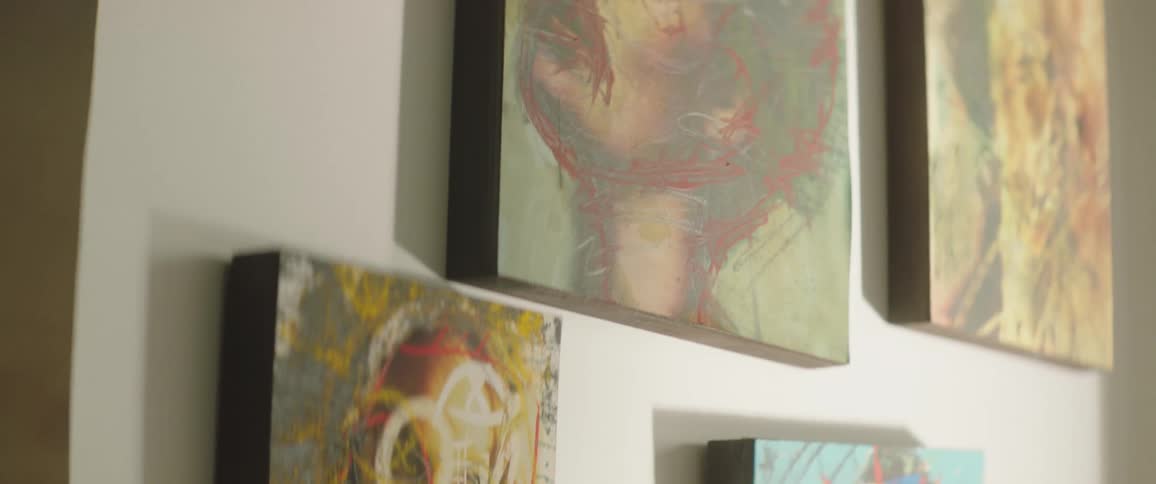 Canvas paintings are hanging displayed on a wall
