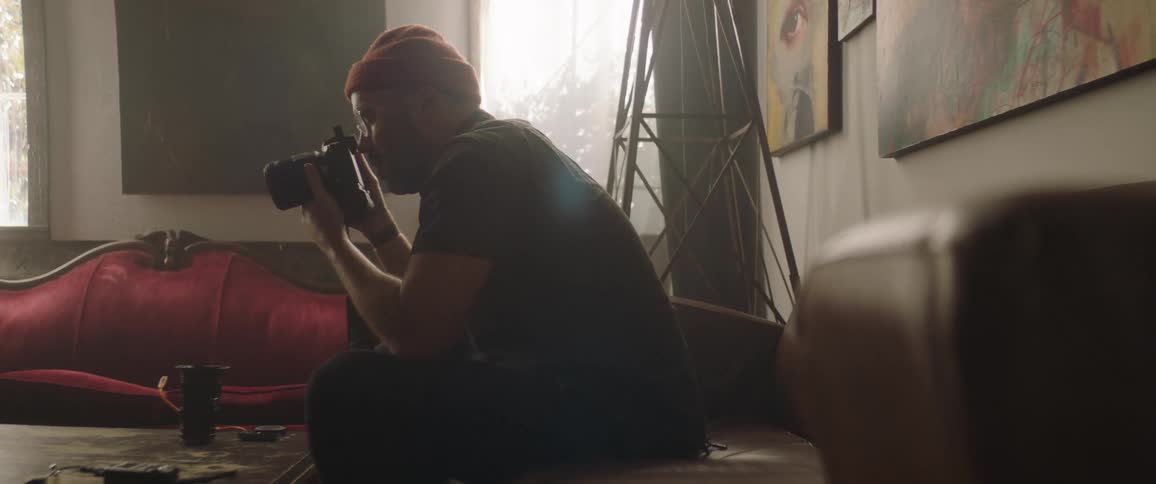Artist taking pictures with a camera inside a dimly lit studio