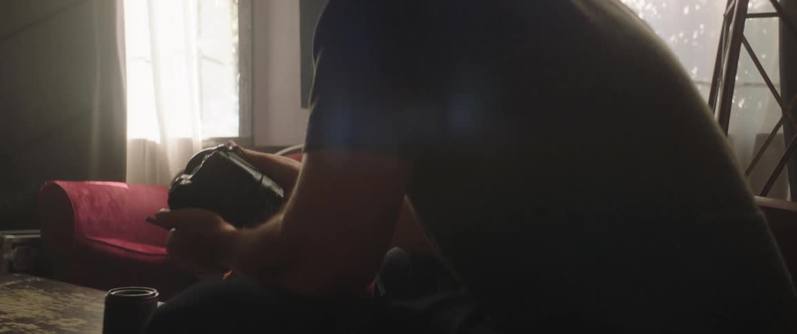 A man is using a camera on the couch