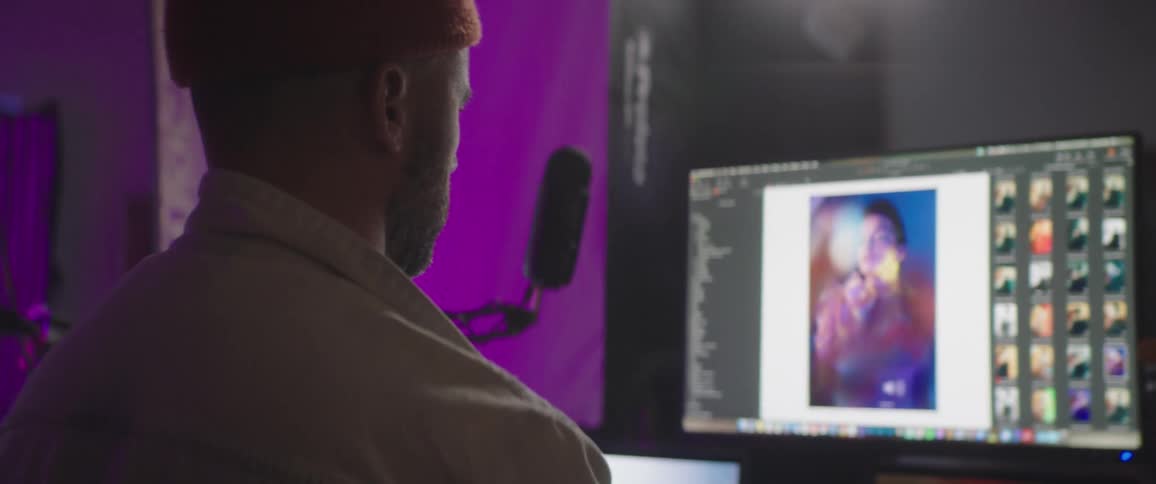 Photographer views pictures on large monitor set near microphone