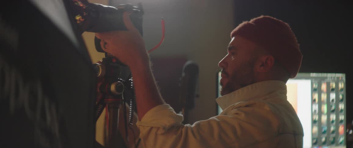 A photographer that is working with a camera in a studio