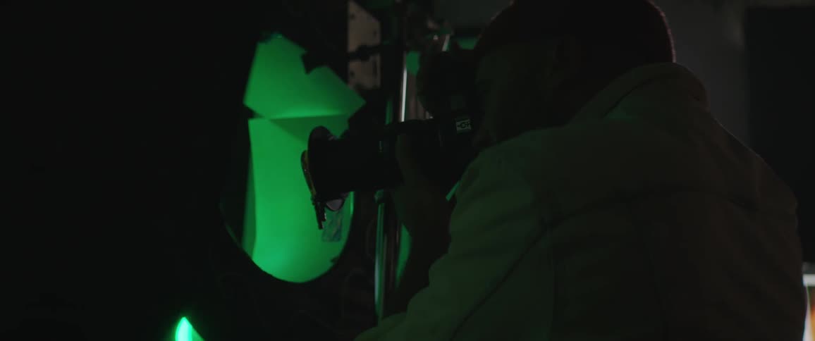 A man is taking pictures with a camera indoors