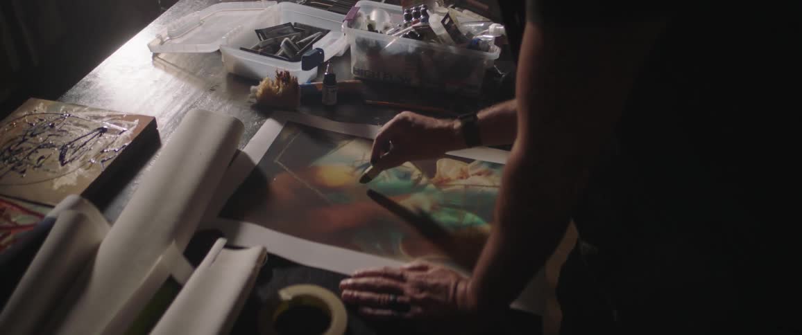 Person is standing and making artwork with a pastel pencil
