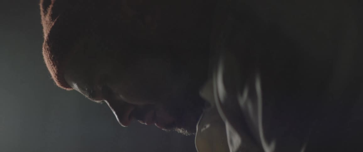 A man is standing in a room and wearing a hat