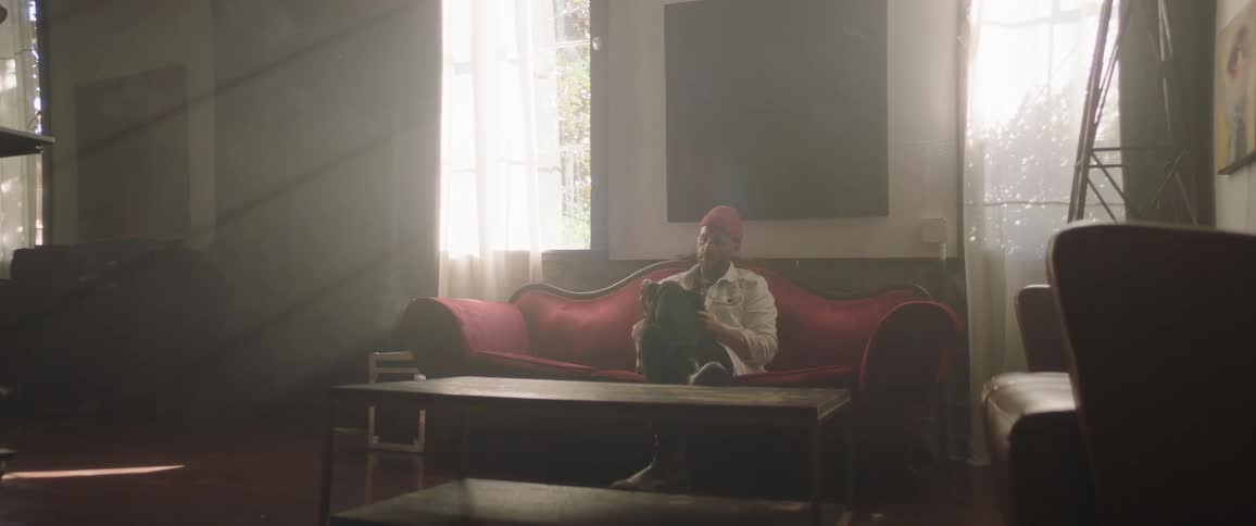 Man sitting on a red velvet couch drawing