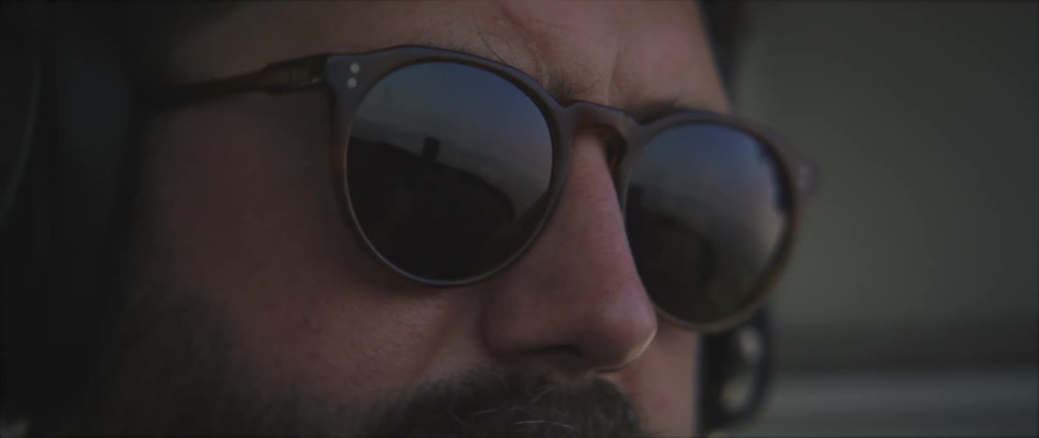Man wearing sunglasses and headphones piloting an airplane