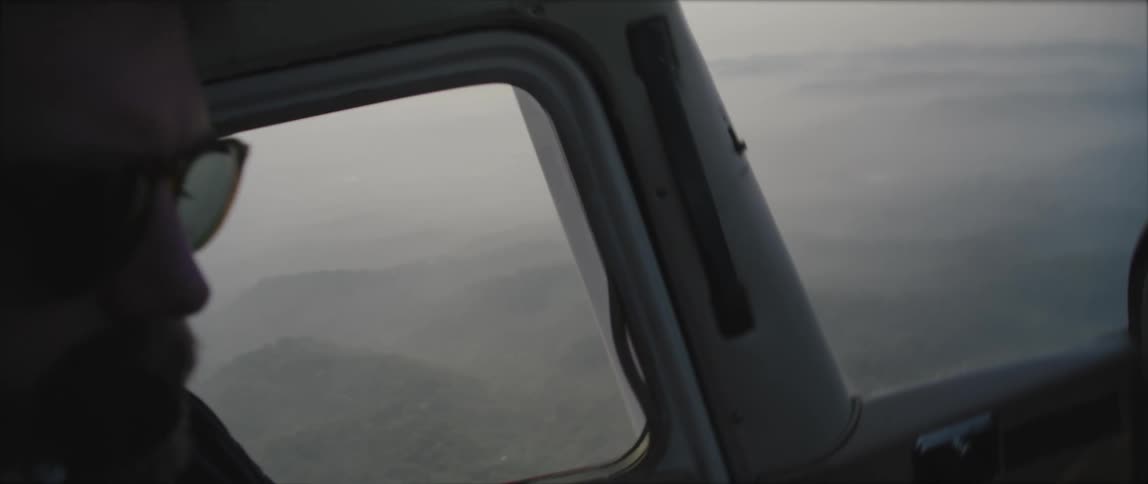 A man flies his plane high over the fog