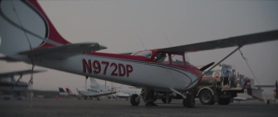 A person opens the door from inside a small airplane