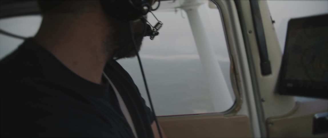 A pilot watches a monitor while piloting a small plane