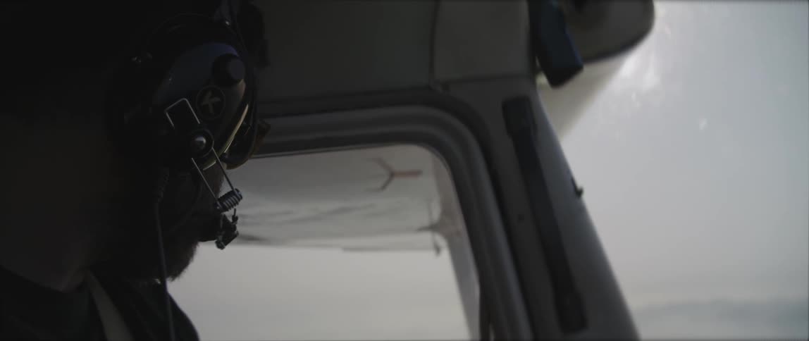 A pilot looks to his side while flying a small plane