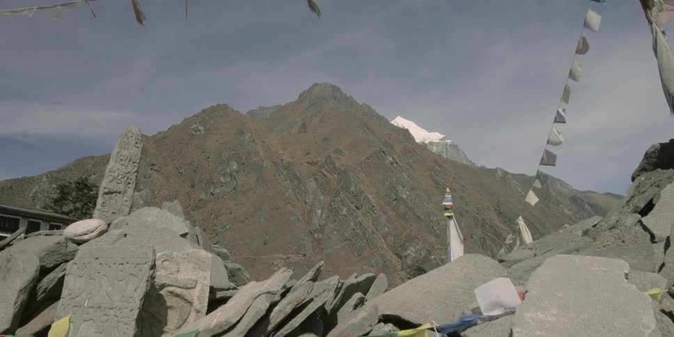 Multi-colored banners hang from a cliffside