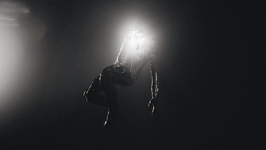 Silhouette of an eerie humanoid figure floating against a dark background
