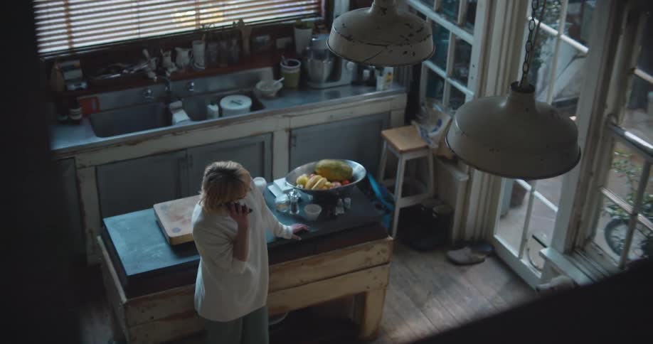 A woman talking on a phone in the kitchen