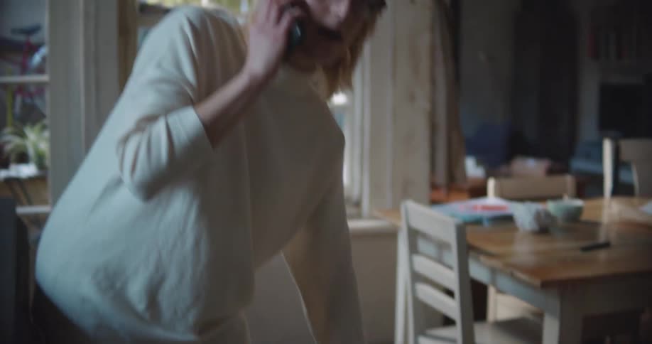 Woman talks on a cellphone as she pets her dog