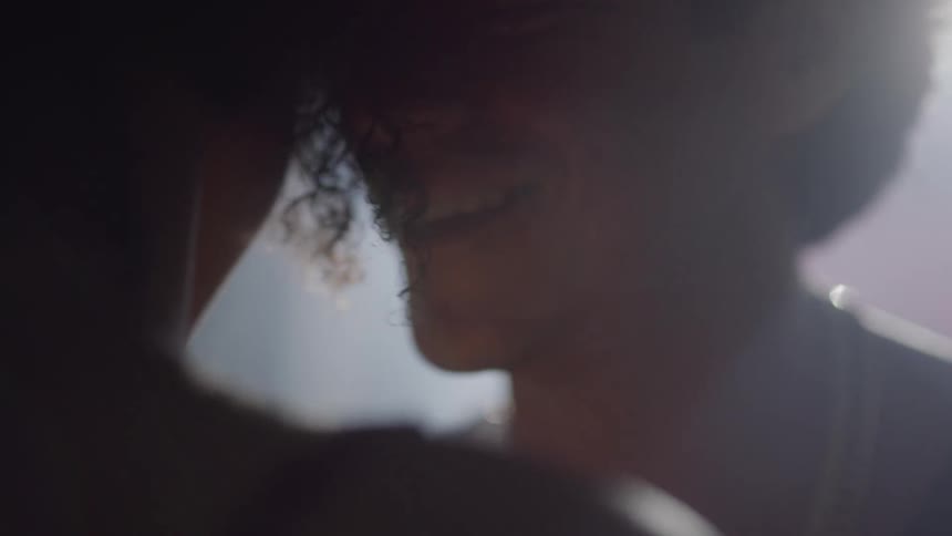 Couple dance closely together as male smiles and talks