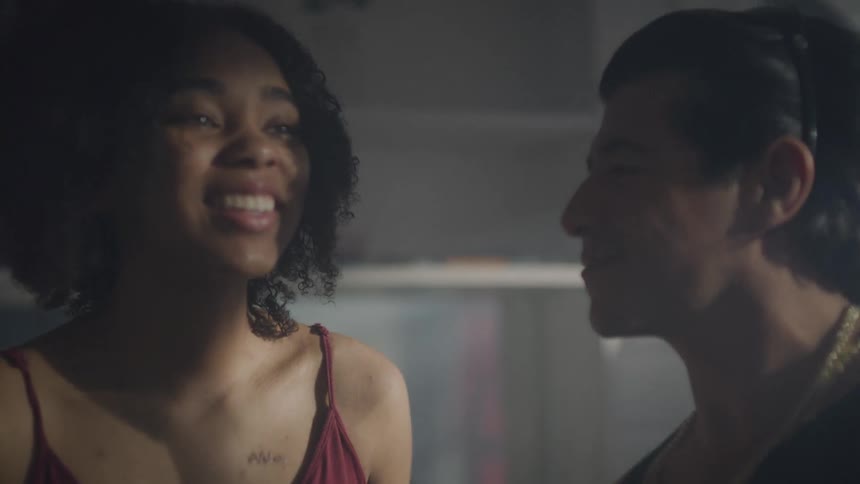 A woman and man dance in a house while the man films with his smartphone