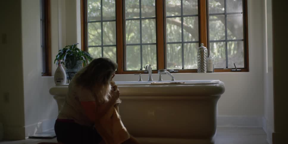Mother wraps a towel around her infant son after a bath and hugs him