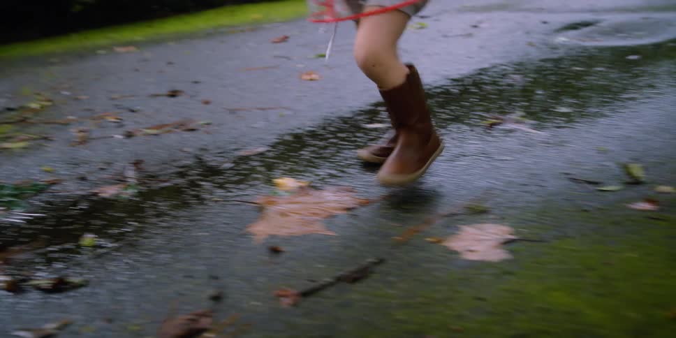 A child walking around outdoors on a rainy day