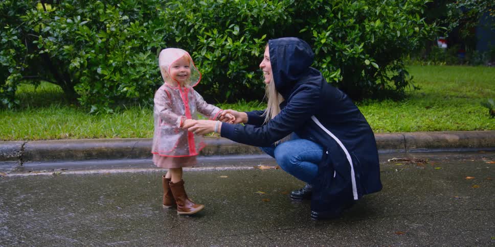 Mother and daughter playing in the rain