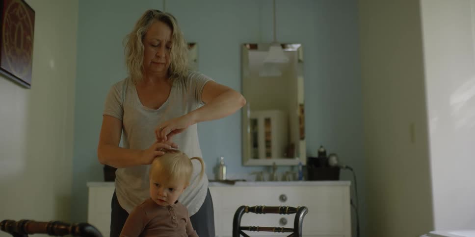 A mother styling the hair of her daughter