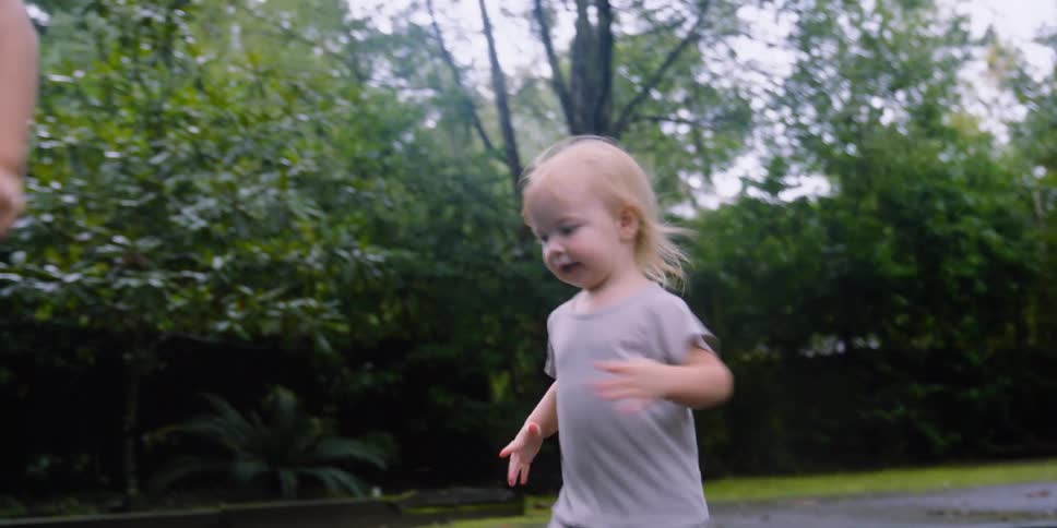 Two children stomp through the puddle in the street