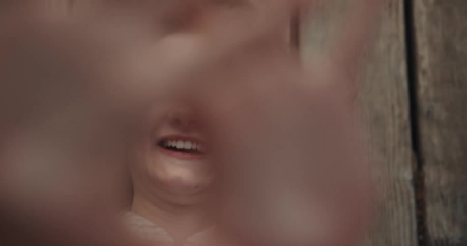 Teenager laughs smiles and sticks out her tongue while laying on planks of wood
