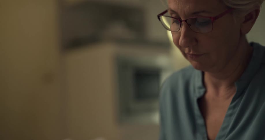 A woman is writing something on a pad at home