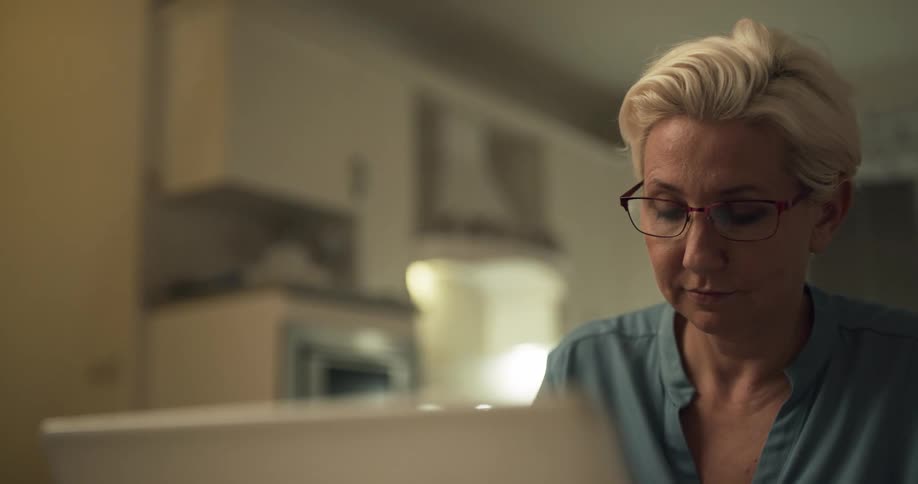 A woman sitting indoors at a table using a laptop computer