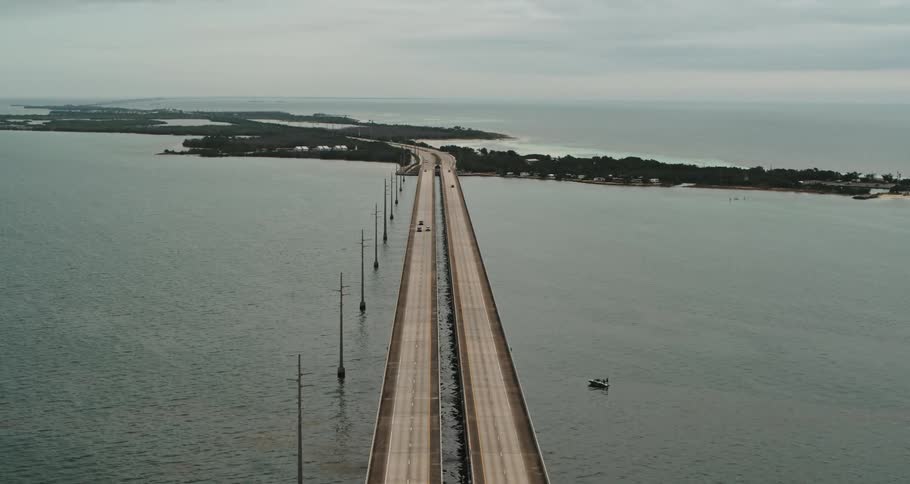 Cars traveling over a bridge spanning coastal islands in the daytime